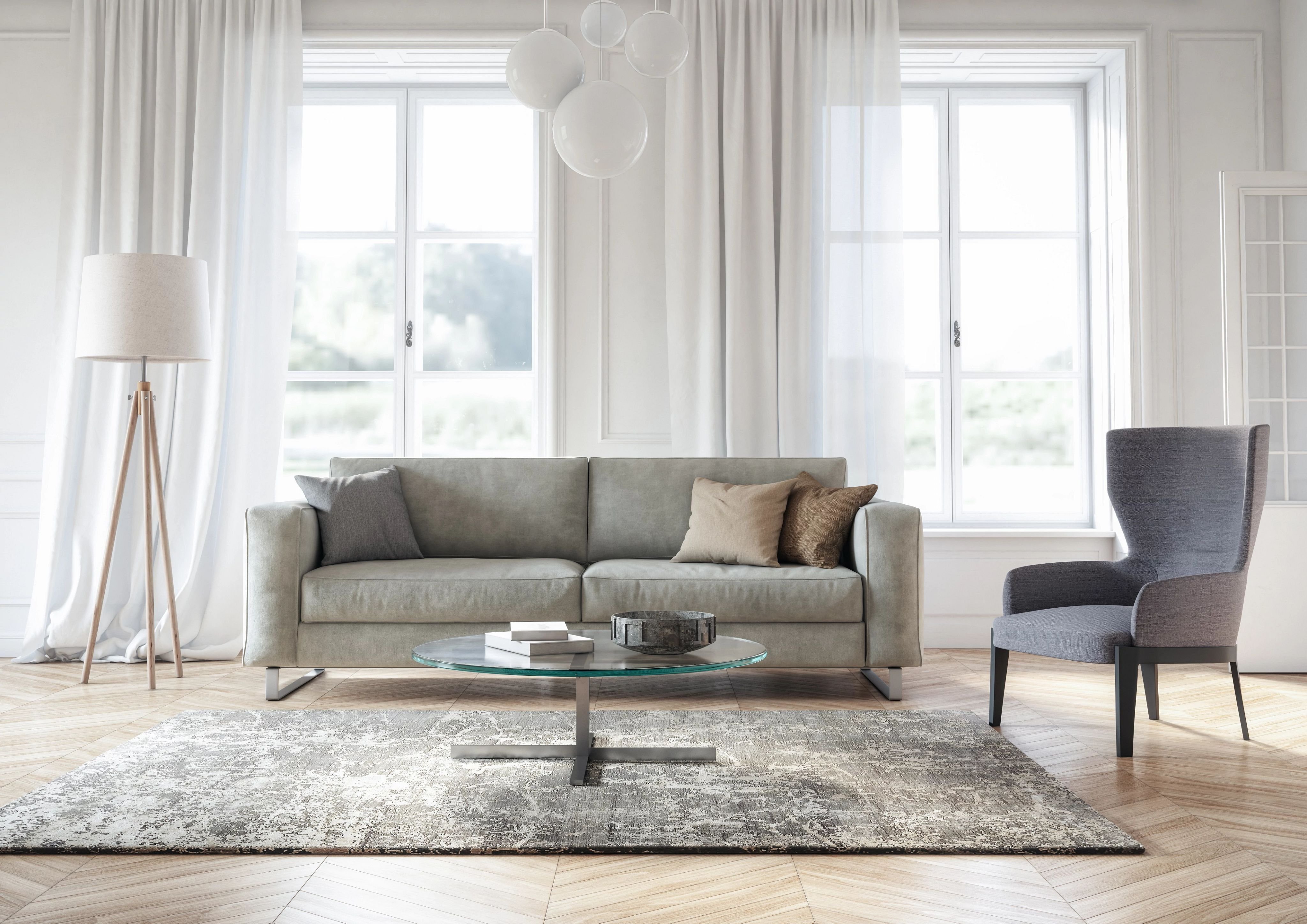 Grey sofa and chair in living room with coffee table and large window
